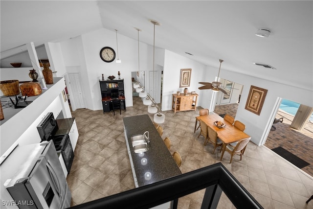 living room with ceiling fan and vaulted ceiling