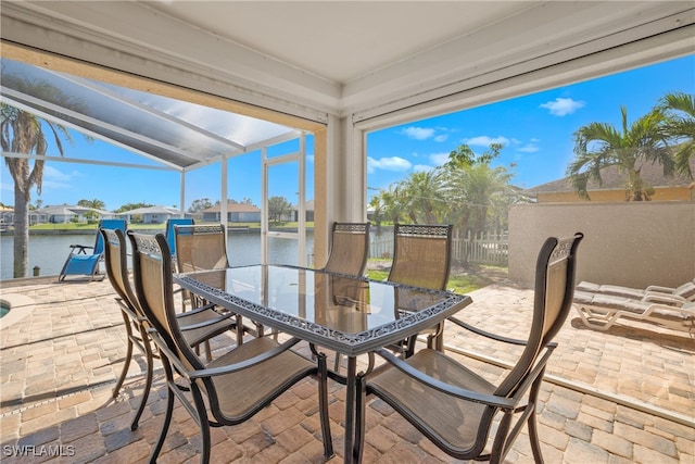 view of patio featuring a water view and a lanai