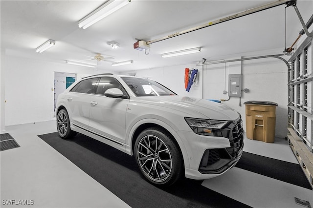 garage with electric panel, a garage door opener, and ceiling fan