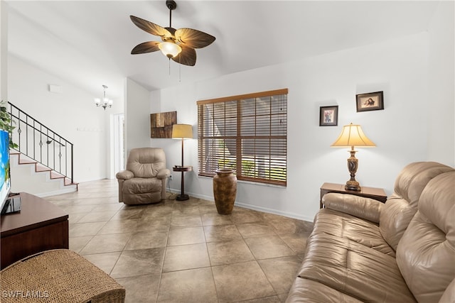 tiled living room featuring ceiling fan with notable chandelier and vaulted ceiling