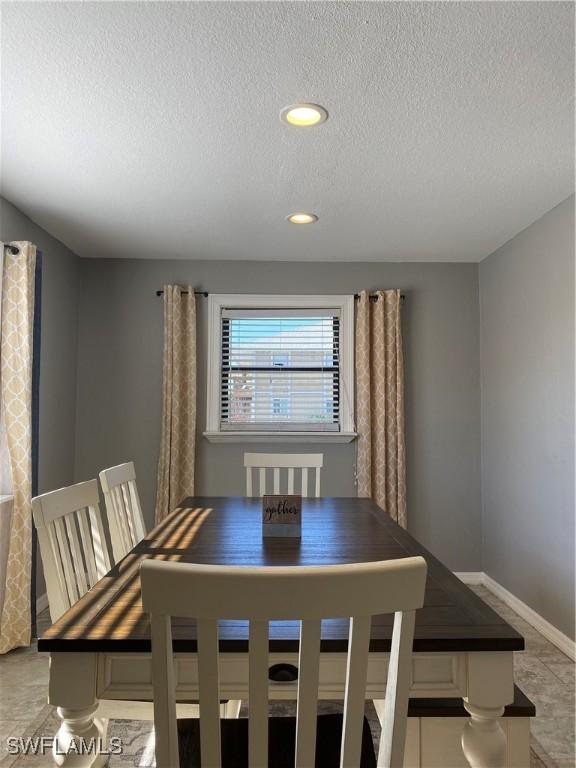 unfurnished dining area featuring light tile patterned floors and a textured ceiling