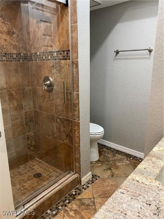 bathroom with toilet and a shower with shower door