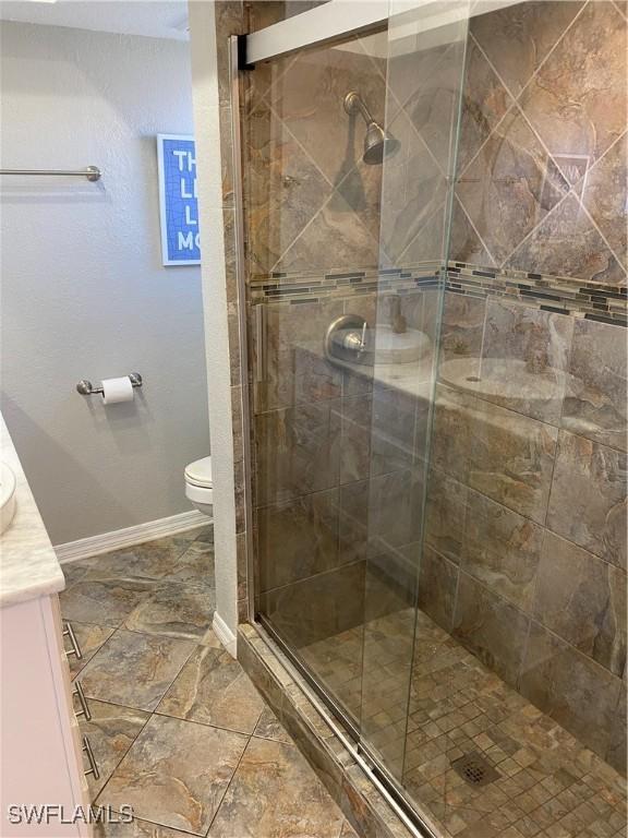 bathroom featuring vanity, toilet, and walk in shower