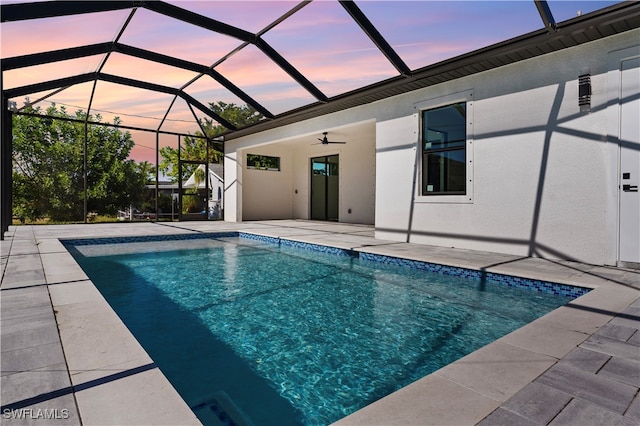 pool at dusk with a patio, ceiling fan, and a lanai