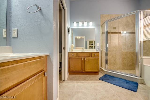 bathroom with toilet, tile patterned floors, walk in shower, and vanity