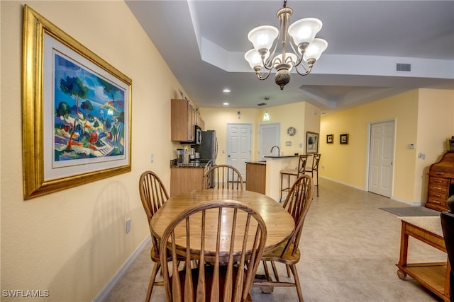 dining space with a chandelier and a raised ceiling