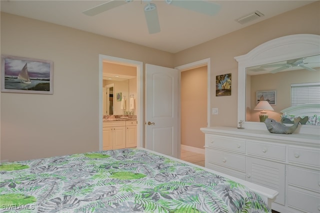 tiled bedroom with ensuite bathroom and ceiling fan