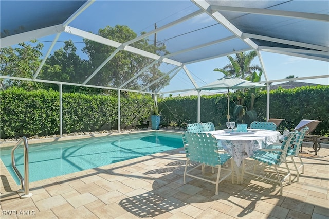 view of pool featuring glass enclosure and a patio area