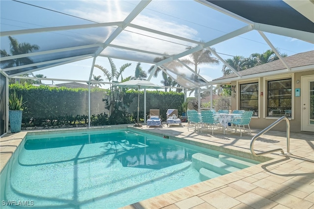 view of pool with glass enclosure and a patio