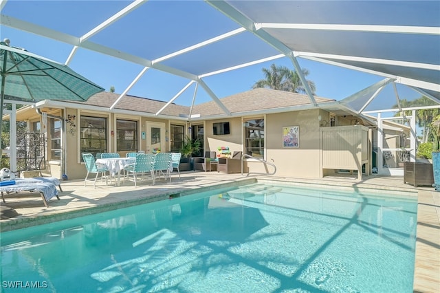 view of swimming pool with glass enclosure and a patio