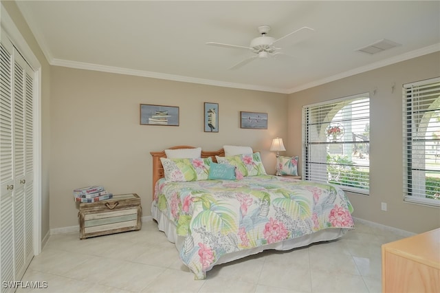 bedroom with light tile patterned flooring, a closet, crown molding, and ceiling fan