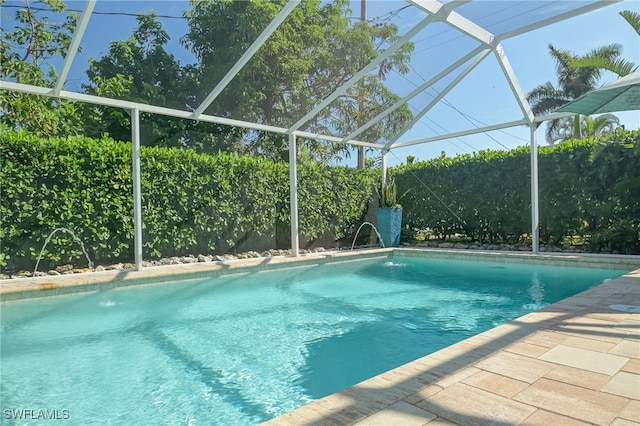 view of pool with pool water feature and a lanai