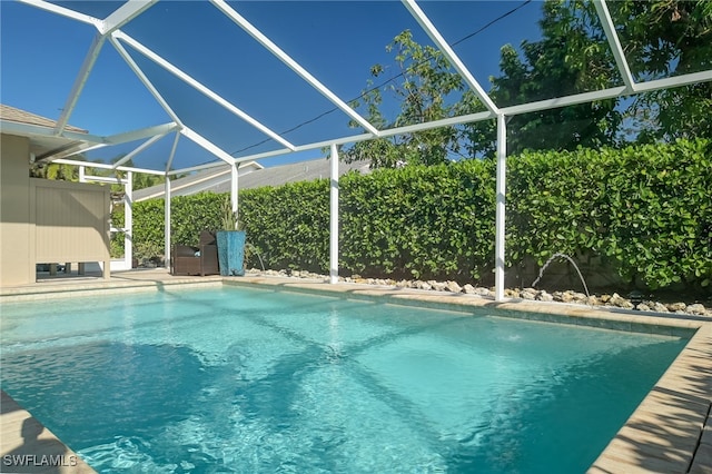 view of swimming pool with glass enclosure and pool water feature