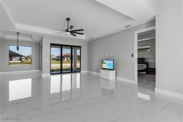 1517 SW 28th Ter, Cape Coral, FL 33914 - unfurnished living room featuring a tray ceiling and ceiling fan