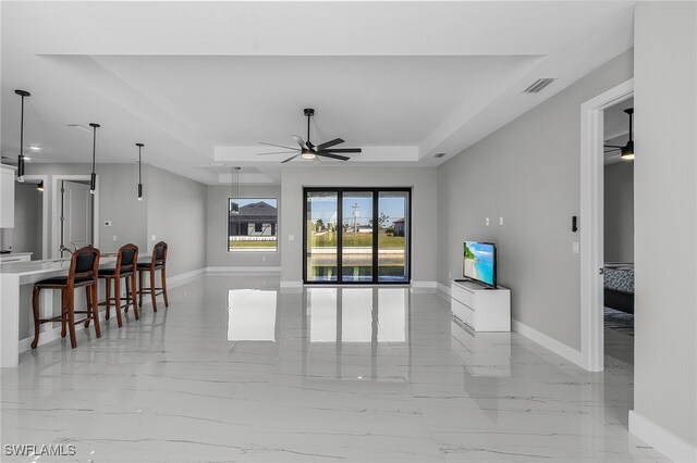 1517 SW 28th Ter, Cape Coral, FL 33914 - living room featuring ceiling fan and a tray ceiling