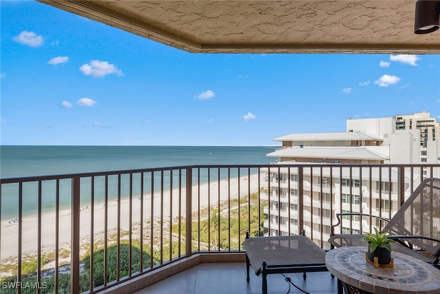 balcony featuring a water view and a beach view