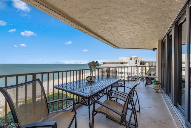 balcony featuring a view of the beach and a water view