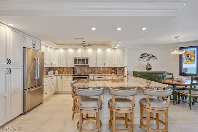 kitchen with appliances with stainless steel finishes, tasteful backsplash, sink, pendant lighting, and white cabinets