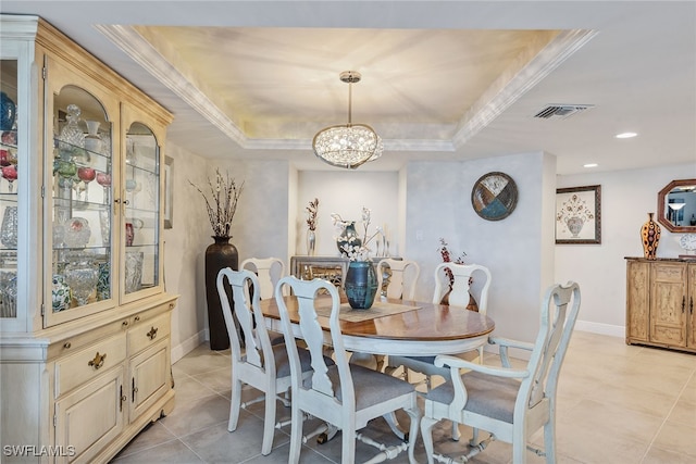 tiled dining space featuring a chandelier, a raised ceiling, and crown molding