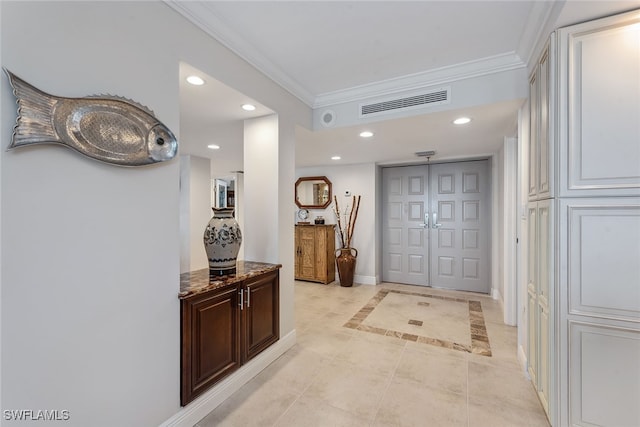 corridor with light tile patterned floors and crown molding