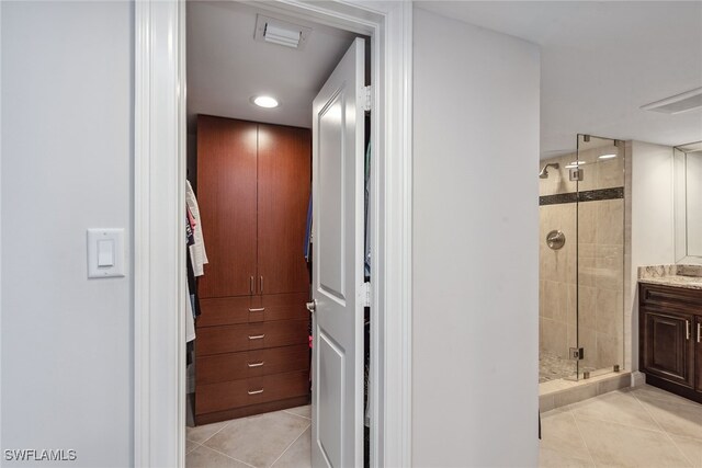 bathroom featuring vanity, tile patterned floors, and a shower with door