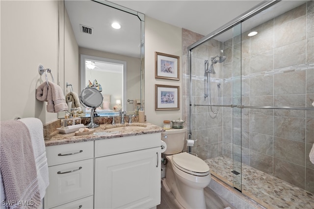 bathroom featuring a shower with door, vanity, wood-type flooring, and toilet