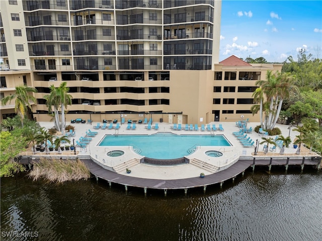 view of swimming pool with a community hot tub and a water view