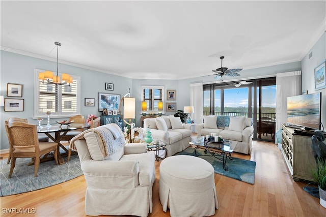 living room featuring crown molding, light hardwood / wood-style floors, and ceiling fan with notable chandelier