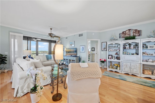 living room with ceiling fan, crown molding, and wood-type flooring