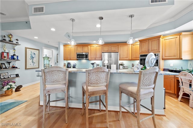 kitchen with pendant lighting, light hardwood / wood-style floors, light stone counters, and appliances with stainless steel finishes