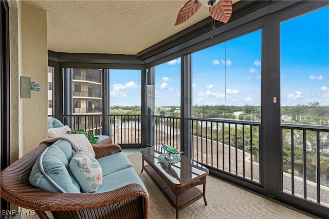 sunroom / solarium with a water view and ceiling fan