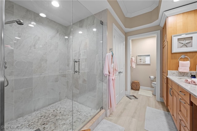 bathroom with crown molding, vanity, an enclosed shower, and toilet