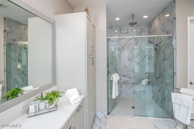 bathroom featuring recessed lighting, marble finish floor, vanity, and a marble finish shower