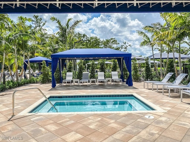 view of pool featuring a hot tub and a patio