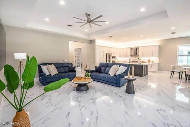 living room featuring a tray ceiling and recessed lighting