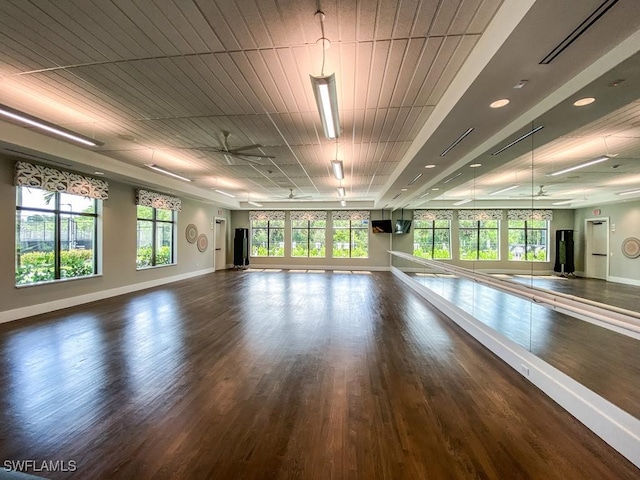 interior space with dark wood-style floors, a healthy amount of sunlight, and baseboards