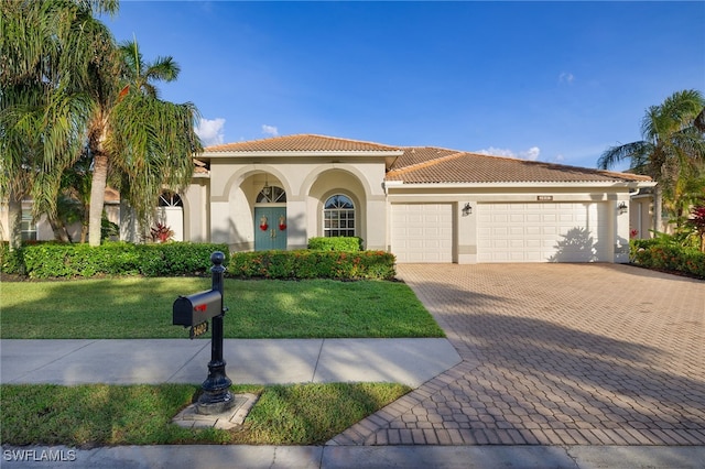 mediterranean / spanish house with a front yard and a garage