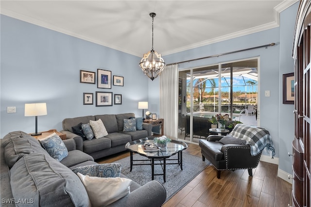 living area featuring dark wood-style flooring, a notable chandelier, crown molding, and baseboards