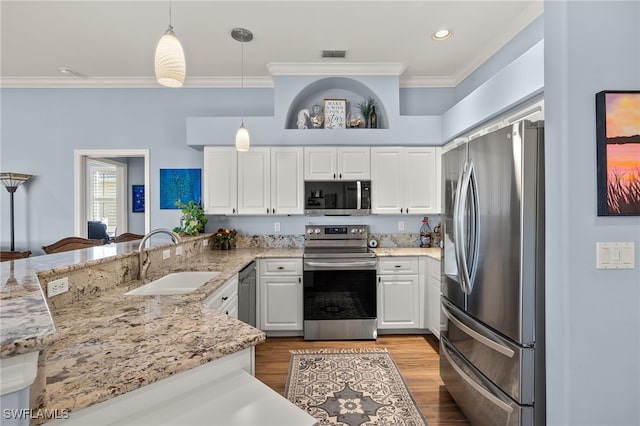 kitchen with crown molding, visible vents, appliances with stainless steel finishes, a sink, and a peninsula