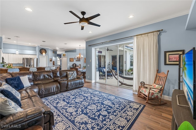 living room featuring baseboards, wood finished floors, ceiling fan with notable chandelier, crown molding, and recessed lighting