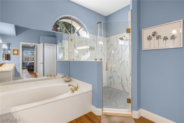 full bathroom featuring wood finished floors, vanity, a marble finish shower, a bath, and ensuite bath