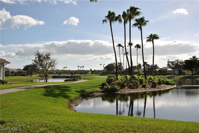 view of home's community with a water view and a lawn