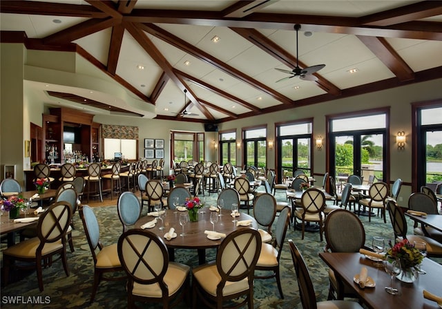 dining area with a ceiling fan, high vaulted ceiling, beam ceiling, and french doors