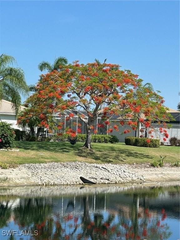 surrounding community featuring a water view and a lawn