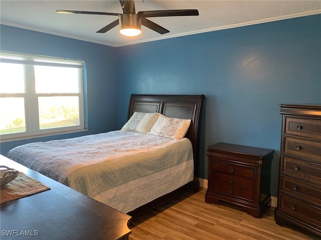 bedroom with light hardwood / wood-style floors, ceiling fan, and crown molding