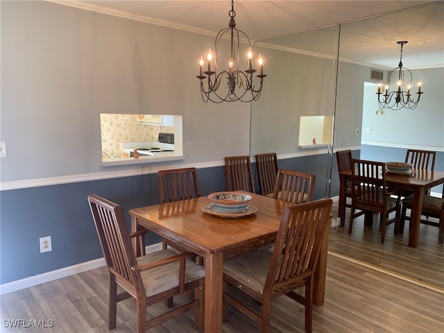 dining space with an inviting chandelier, wood-type flooring, and ornamental molding