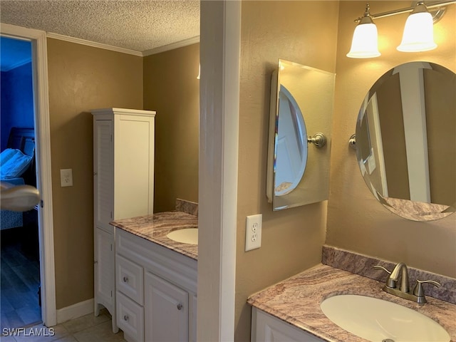 bathroom featuring vanity, a textured ceiling, ornamental molding, and tile patterned flooring