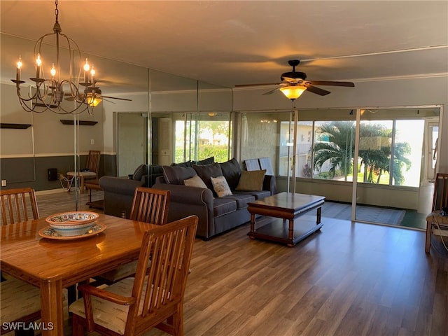 dining room with hardwood / wood-style flooring and ceiling fan with notable chandelier