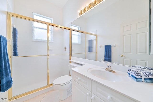 bathroom featuring tile patterned floors, vanity, a shower with shower door, and toilet