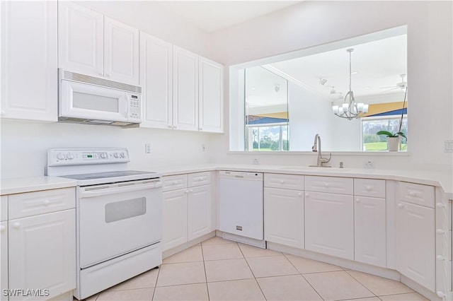 kitchen featuring white appliances, white cabinets, sink, a notable chandelier, and light tile patterned flooring